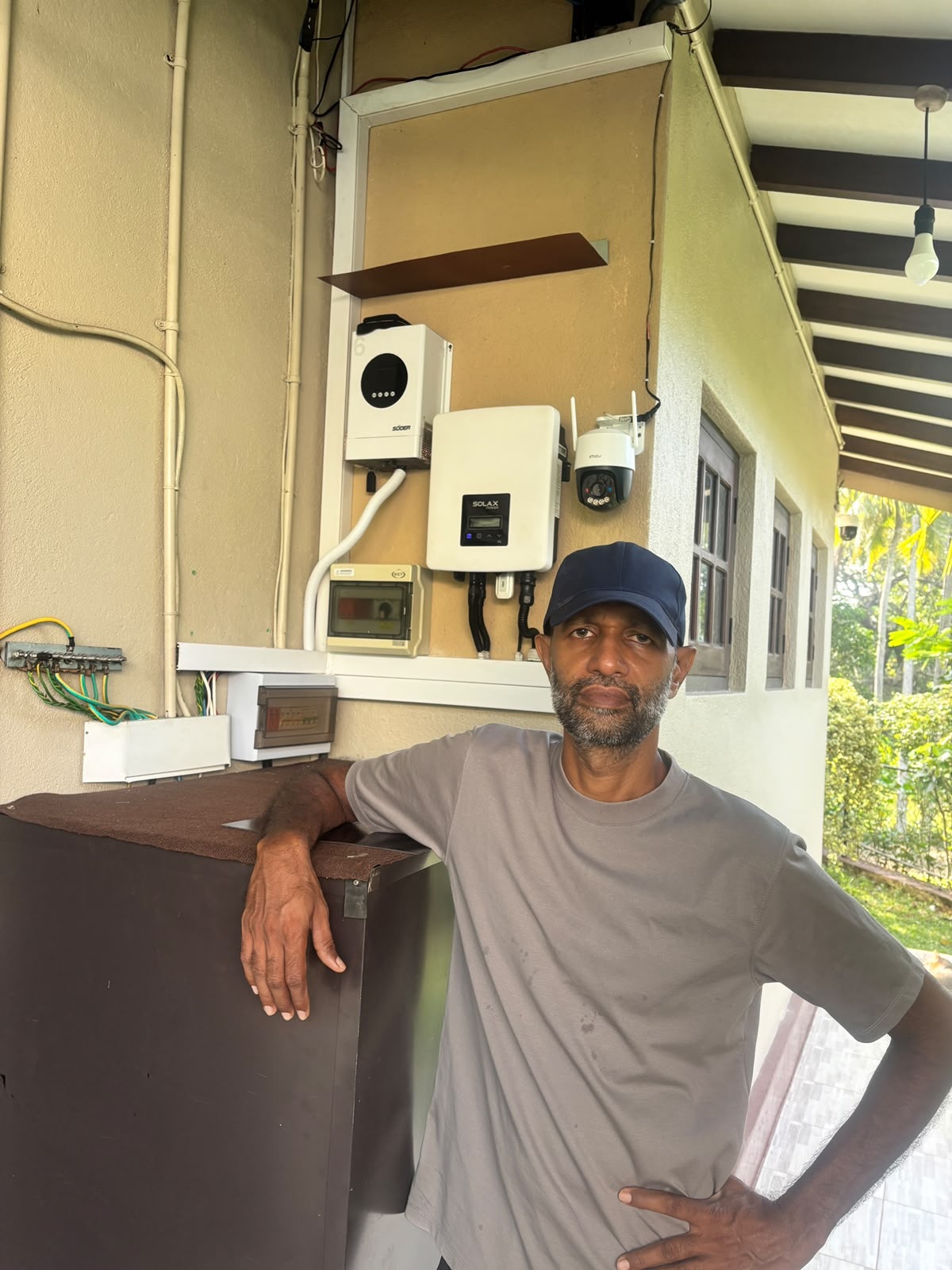 Harshana in front of his battery cupboard